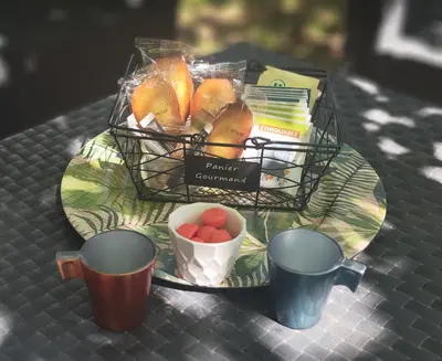 a tray with a basket of fruit and a plate with cups at Studio Goya climatisé et jardin 2 nuits minimum in Castres