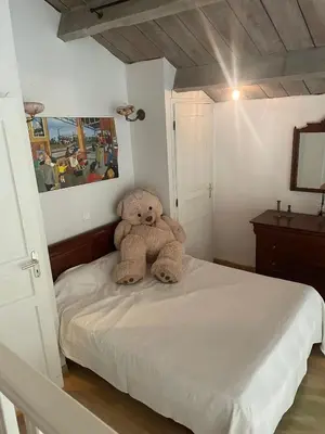 a teddy bear sitting on a bed in a bedroom at Chic trainstation in Pomas