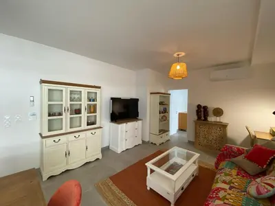 a living room with a couch and a tv at TRES BEL F2 NEUF, GRANDE TERRASSE, TRES BIEn SITUE in Narbonne