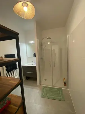 a bathroom with a shower with a sink and a mirror at TRES BEL F2 NEUF, GRANDE TERRASSE, TRES BIEn SITUE in Narbonne