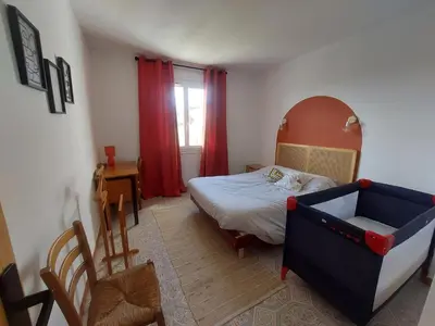 a small bedroom with a bed and a chair at Villa au calme, tout confort clim piscine wifi 7 personnes in Caunes-Minervois