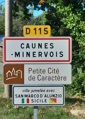 a street sign with several signs on a pole at Villa au calme, tout confort clim piscine wifi 7 personnes in Caunes-Minervois