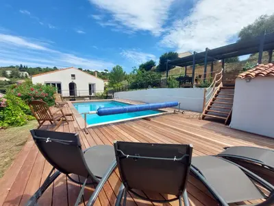a deck with chairs and a swimming pool at Villa au calme, tout confort clim piscine wifi 7 personnes in Caunes-Minervois