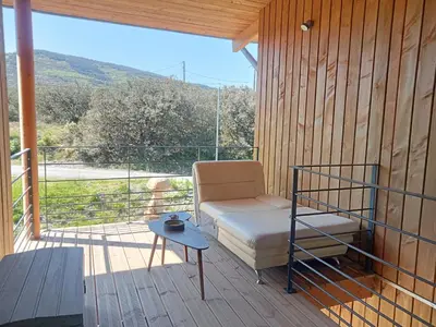 a room with a bed and a table on a balcony at Ecogîtes Camparols in Prémian
