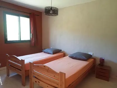 two twin beds in a room with a window at Ecogîtes Camparols in Prémian