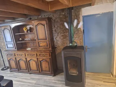 a living room with a fireplace and a wooden cabinet at Chez Loulou du Linas - Bugarach in Bugarach