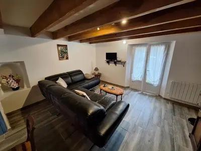 a living room with a leather couch and a table at Chez Loulou du Linas - Bugarach in Bugarach