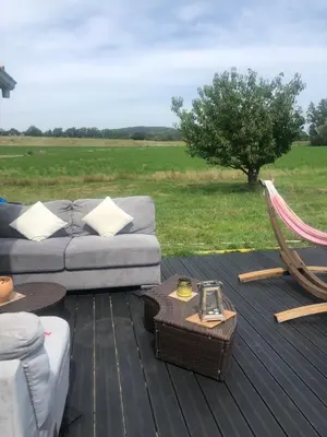 a couch and a hammock on a wooden deck at Chez Anna et JL in Navès