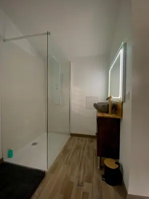 a bathroom with a sink and a glass shower at Chez Anna et JL in Navès