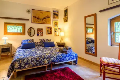 a bedroom with a blue bed and a mirror at Moulin St Pierre bord - Au calme en bord de Rivière in Limoux