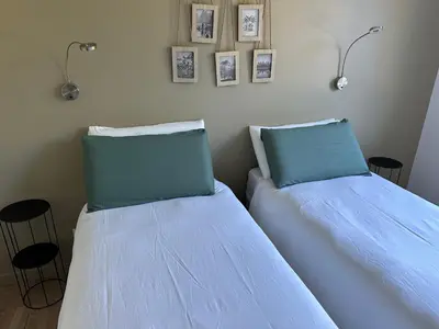 two beds sitting next to each other in a bedroom at Le repaire du châtaignier, Maison à la campagne, 8 pers, 4 ch, Sidobre in Ferrières