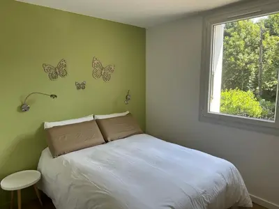 a bedroom with a bed with butterflies on the wall at Le repaire du châtaignier, Maison à la campagne, 8 pers, 4 ch, Sidobre in Ferrières