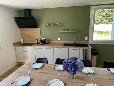 a kitchen with a table with a vase of flowers on it at Le repaire du châtaignier, Maison à la campagne, 8 pers, 4 ch, Sidobre in Ferrières