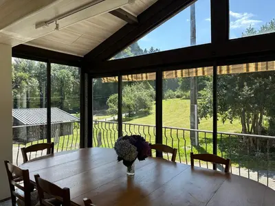 a dining room with a table and large windows at Le repaire du châtaignier, Maison à la campagne, 8 pers, 4 ch, Sidobre in Ferrières