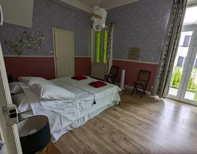 a bedroom with a bed and two chairs in it at Grande maison proche Carcassonne 10 p piscine spa sauna Le Grand Chalet Bellevue in Cavanac