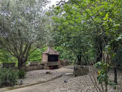 a garden with a brick shelter in a park at Grande maison proche Carcassonne 10 p piscine spa sauna Le Grand Chalet Bellevue in Cavanac