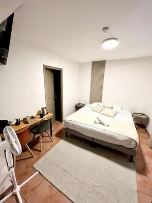 a bedroom with a bed and a desk and a table and chair at Chambre de la bastide 102 in Carcassone