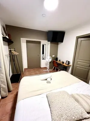 a bedroom with a large white bed in a room at Chambre de la bastide 102 in Carcassone
