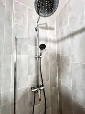 a shower with a shower head in a bathroom at Chambre de la bastide 102 in Carcassone