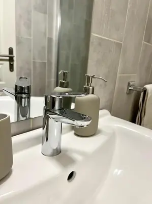 a bathroom sink with a faucet and a mirror at Chambre de la bastide 102 in Carcassone