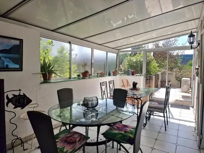 a dining room with a glass table and chairs at Ma Zénitude in Palaja