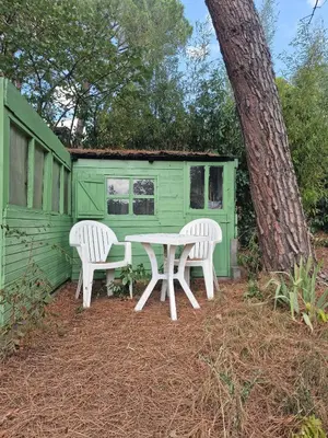 a table and two chairs in front of a green house at Ma Zénitude in Palaja