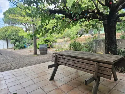 a wooden bench sitting next to a tree at Ma Zénitude in Palaja
