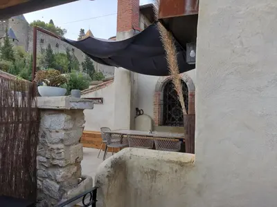 a patio with a table and a black hammock at Le Belvédère St Gimer in Carcassonne
