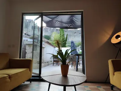 a living room with a couch and a table and a patio at Le Belvédère St Gimer in Carcassonne