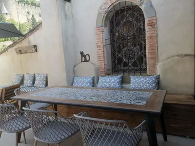 a table and chairs on a patio with a window at Le Belvédère St Gimer in Carcassonne
