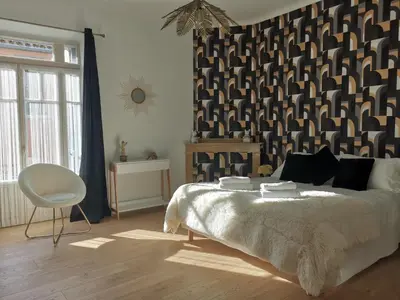 a bedroom with a bed and a black and white wall at Le Belvédère St Gimer in Carcassonne
