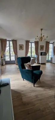 a living room with a blue chair and a couch at Via Narbona in Narbonne