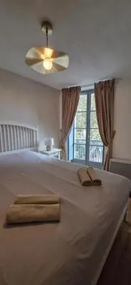 a bedroom with a large bed with a ceiling fan at Via Narbona in Narbonne