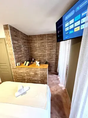 a room with a bed and a tv on the wall at Les chambres de la bastide - 103 in Carcassonne