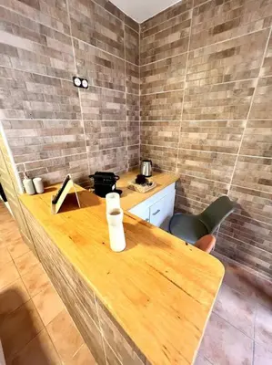 a wooden table in a room with a counter and chairs at Les chambres de la bastide - 103 in Carcassonne
