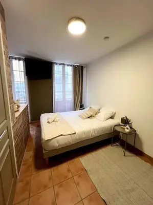 a bedroom with a large bed in a room at Les chambres de la bastide - 103 in Carcassonne
