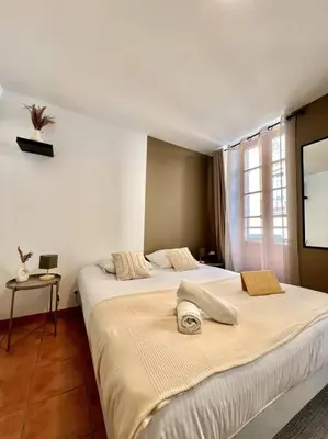 a bedroom with two beds and a tv on the wall at Les chambres de la bastide - 105 in Carcassone
