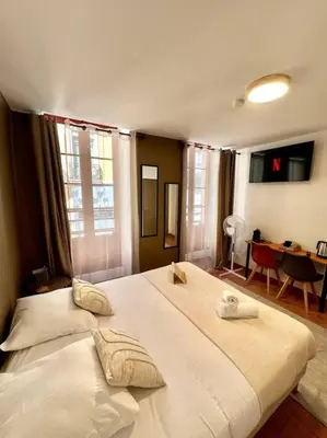 a bedroom with a large white bed with two towels on it at Les chambres de la bastide - 105 in Carcassone