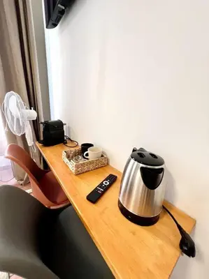 a wooden table with a tea kettle and a remote control at Les chambres de la bastide - 105 in Carcassone