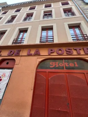 a building with a sign above a red door at Les chambres de la bastide - 105 in Carcassone
