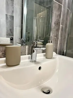 a bathroom with a sink with two soap dispensers on it at Les chambres de la bastide - 105 in Carcassone