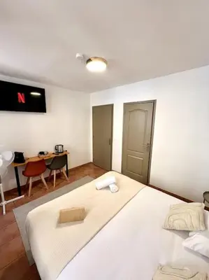 a bedroom with a large white bed and a desk at Les chambres de la bastide - 105 in Carcassone