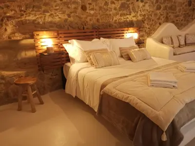 a bedroom with two beds and a stool in a room at Le Clos Barbacane in Carcassone