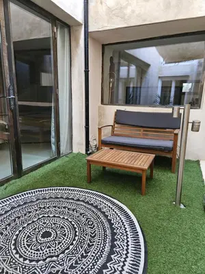 a patio with a bench and a mandala rug at Le Clos Barbacane in Carcassone