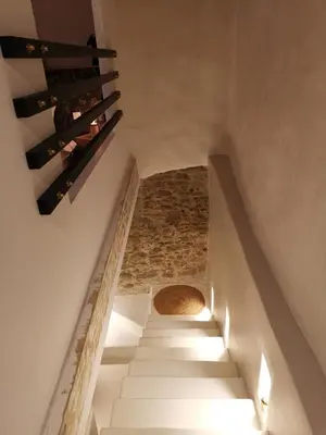 a staircase leading up to a room with wine bottles at Le Clos Barbacane in Carcassone