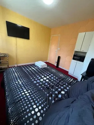 a large teddy bear sitting in front of a bedroom at Hotel Castres Chambre Simple in Castres