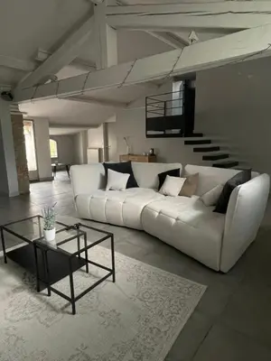 a living room with a white couch and a table at La Tuilerie du Bazalac in Trèbes