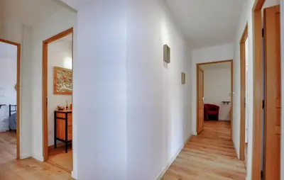 a hallway with white walls and wooden floors at 4 Bedroom Gorgeous Home In Tournissan in Tournissan