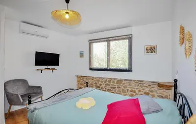 a bedroom with a bed and a chair and a television at 4 Bedroom Gorgeous Home In Tournissan in Tournissan