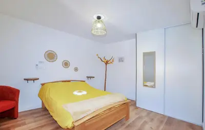 a bedroom with a yellow bed and a red chair at 4 Bedroom Gorgeous Home In Tournissan in Tournissan